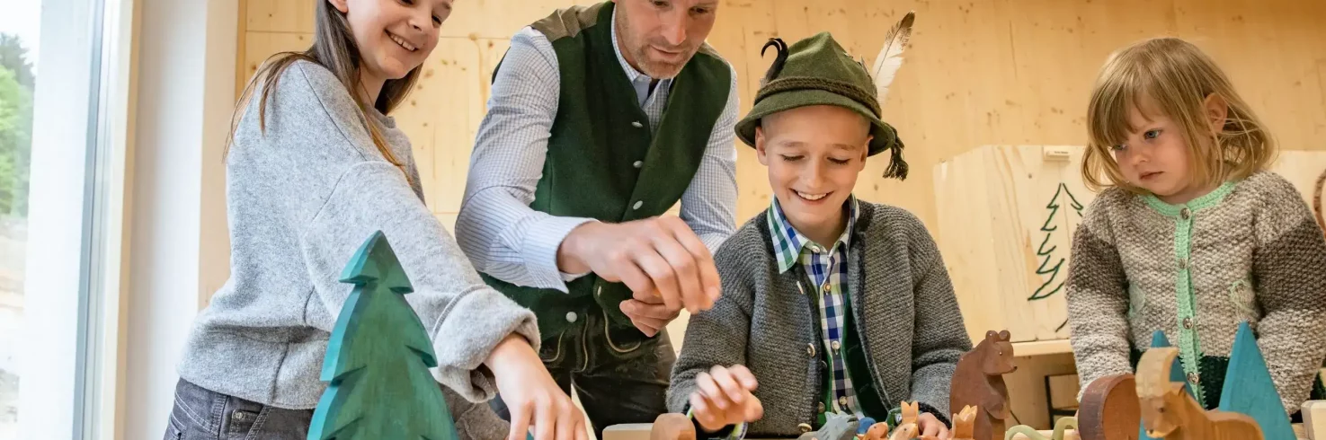 Familie spielt mit Holztieren - Jahresprogramm Naturwelten Steiermark 2024