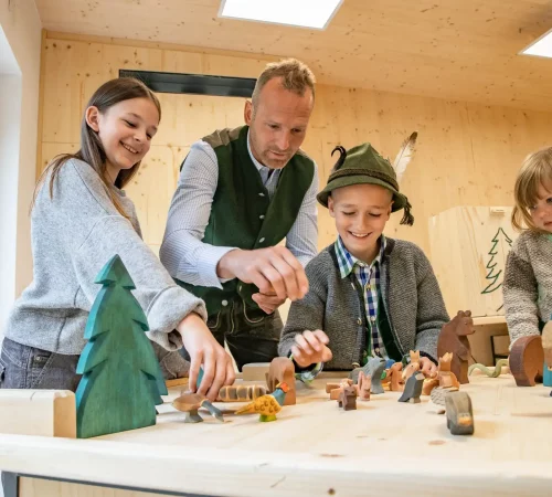Familie spielt mit Holztieren - Jahresprogramm Naturwelten Steiermark 2024
