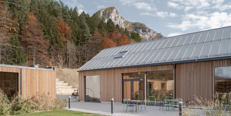 Herbst in den Naturwelten, Holzgebäude, Bunte Bäume im Hintergrund