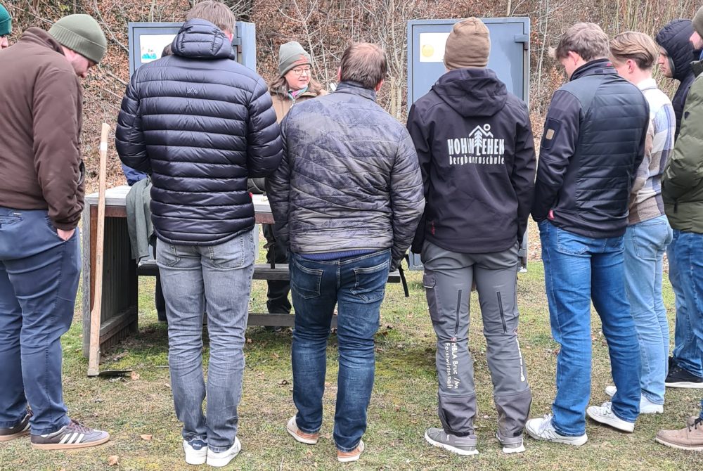 Gruppe von Jugendlichen erkundet gemeinsam mit einer Betreuungsperson die Naturwelten im Außenbereich.